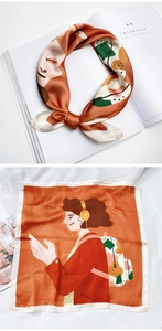Détail d'un foulard en soie orange avec illustration moderne d'une fille au casque