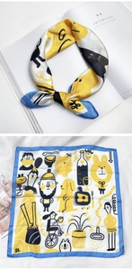 Détail d'un foulard en soie à imprimé dessin animé avec motifs animaux et bords bleus