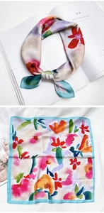 Détail d'un foulard en soie aux motifs floraux de peinture à l'huile et bords bleu clair