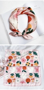 Détail d'un foulard en soie rose à motif floral et imprimés botaniques sur magazine