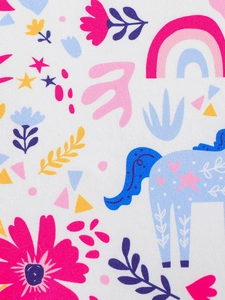 Detailed macro view of colorful unicorn and floral print on white cotton fabric
