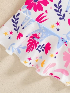 Detail of girls' summer outfit featuring colorful floral and unicorn prints on ruffled hem