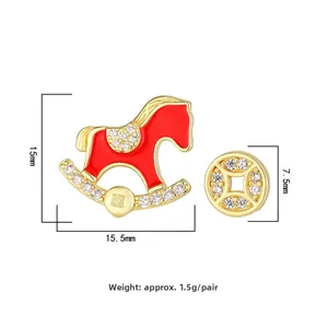 Vue détaillée de boucles d'oreilles asymétriques cheval à bascule rouge et pièce dorée