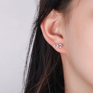 Boucles d'oreilles feuilles en argent avec zircons roses et blancs sur un mannequin
