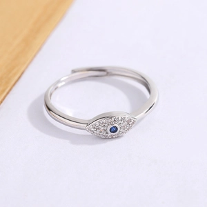 Adjustable silver Evil Eye ring with blue gemstone and white zircon stones on white background