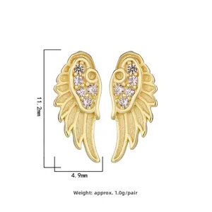 Detailed view of wing-shaped stud earrings with sparkling cubic zirconia on gold metal