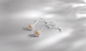 Close-up of S925 sterling silver daisy drop earrings with golden core and long wave chain