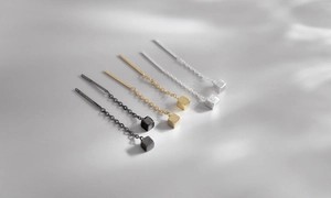 Detail of cube pendants on ear threads in silver gold and black with matte finish