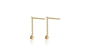 Macro detail of gold-finish chain earrings featuring minimalist matte square cube pendants