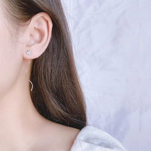 Elegant long tassel earrings with silver flower studs and zircon wave pendants on a model