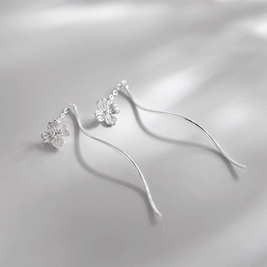 Silver flower tassel drop earrings featuring delicate S-shaped curved threader chains