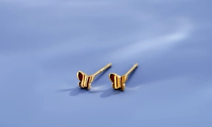Gros plan détaillé de boucles d'oreilles papillon en argent S925 avec finition dorée