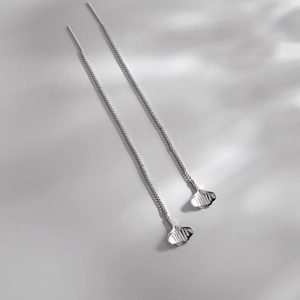 Elegant long tassel threader earrings with silver ginkgo leaf pendants on a minimal surface