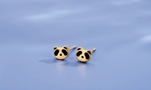 Vue macro de boucles d'oreilles panda mignonnes en métal doré et émail noir