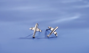 Gros plan de boucles d'oreilles avion en argent S925 poli sur fond de soie douce