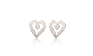 Macro detail of brushed silver heart studs showing hollow nested design and matte texture