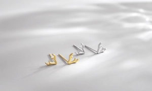 Vue détaillée de boucles d'oreilles bois de renne polies en or et argent avec lumière douce
