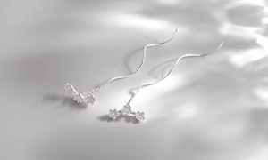 Detail of s925 silver long tassel earrings with three delicate floral charms in matte finish