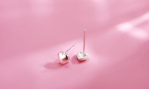 Close-up of polished S925 sterling silver heart studs with hallmark detail
