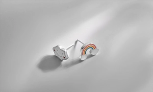Macro view of S925 silver asymmetric earrings featuring rainbow and smiling cloud designs