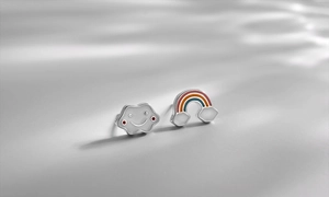 Macro shot of asymmetric s925 silver stud earrings with colorful enamel rainbow and smiling cloud