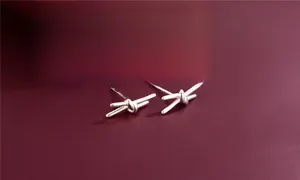 Macro shot of S925 sterling silver knot earrings with hallmark detail and modern design