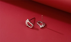 Macro view of S925 sterling silver stud earrings in cute foot shape with polished finish