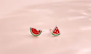 Macro view of handmade enamel watermelon earrings with vibrant red and green textures