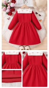 Detailed close-up of floral embroidery on a girl's red dress with white doll collar