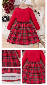 Detail of red and black plaid girl's dress with Christmas bow and high waist sewing