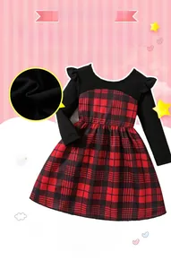 Detail of red and black plaid skirt and black knit top with ruffled shoulder design