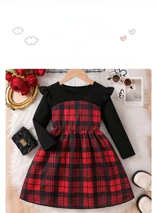 Detail of red plaid pattern and black knitted fabric of the girl's long sleeve winter dress