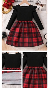 Detail of red and black plaid pleated skirt with black ribbed knit and ruffle shoulders