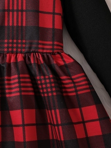 Girls red plaid New Year dress with black knit top and pleated skirt detail