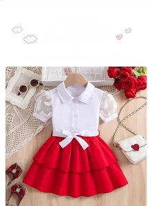 Détail de l'ensemble fille montrant manches en dentelle, fleurs 3D et nœud à la taille