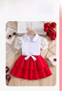 Détail de l'ensemble fille avec manches en dentelle et jupe rouge à volants avec nœud