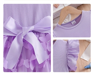 Detail of girls purple mesh dress with butterfly appliques and large satin bow at waist
