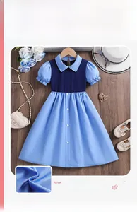Detail eines blauen Mädchenkleides mit Puffärmeln, einreihigen Knöpfen und Tüll-Lagen