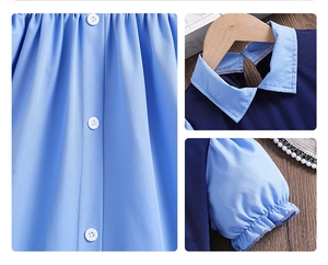 Details von Puffärmeln und weißen Knöpfen an einem blauem Patchwork-Mädchenkleid