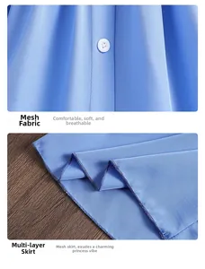 Detailansicht aus blauem Netzstoff mit weißen Knöpfen und mehrlagigem Saum des Mädchenkleids