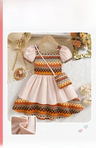 Detail of girls bohemian dress with pink puff sleeves and matching ethnic pattern crossbody bag