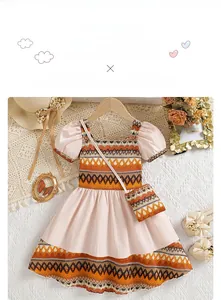 Detail of bohemian girl dress with puff sleeves and ethnic geometric pattern including bag
