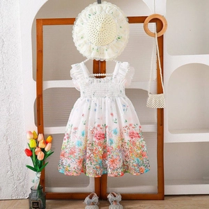 Detalle del vestido de verano floral para niñas y conjunto de sombrero de sol en un marco
