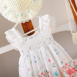 Detalle de vestido de verano floral para niñas con sombrero de sol a juego en gasa ligera