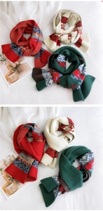 Close-up of winter knit scarves in red, cream, and green with pixelated holiday patterns