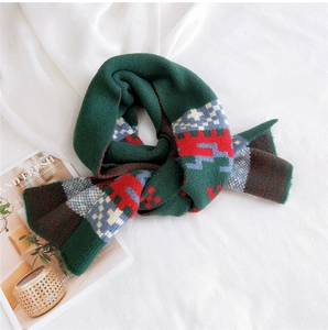 Detail of green knitted scarf with festive geometric patterns and soft texture