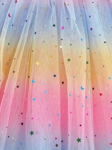 Macro detail of rainbow gradient tulle with glittery star and moon sequins for kids tutu