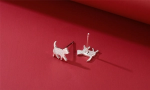 Detail of brushed silver cat stud earrings showing sleek silhouette and texture