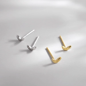 Minimalist silver and gold clover leaf stud earrings shown in natural soft light