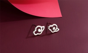 Macro shot of polished S925 silver stud earrings with an abstract cloud swirl design